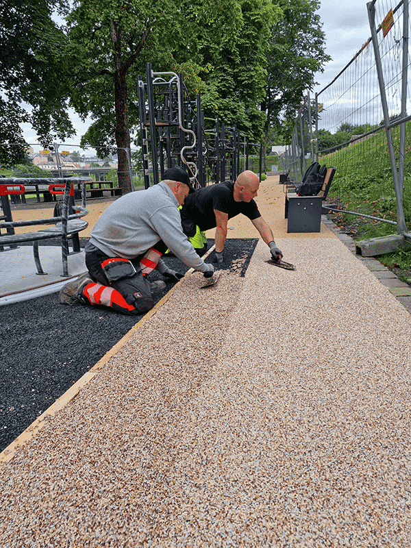 Her legger Søbstad-gartnerne siste hånd på verket av falldempende underlag i parken ved Nidarosdomen. Foto: Søbstad as 